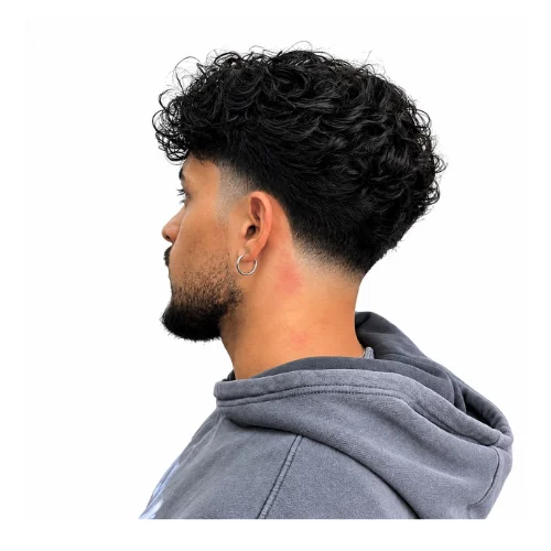 Low taper fade curly hair messy hairstyle featuring tousled curls on top, natural texture, and clean low taper faded sides for a relaxed look