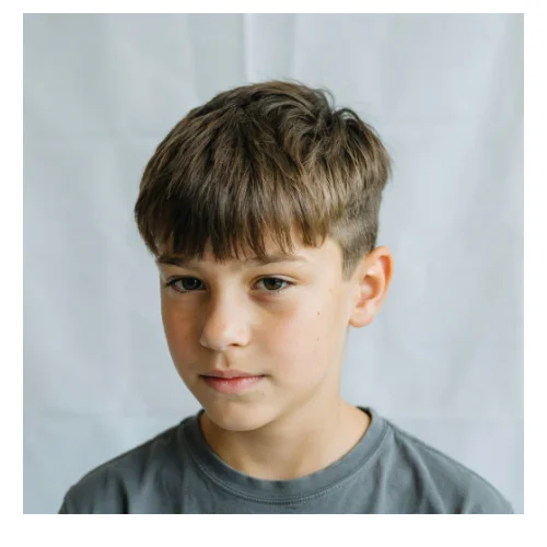 French crop textured fringe hairstyle featuring a textured top, defined fringe across the forehead, and clean tapered sides for a modern and stylish appearance