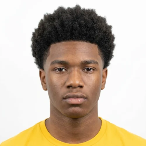 Black man with curly hair and a low taper fade haircut
