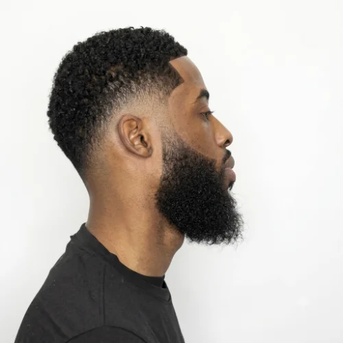 Black man with a low taper fade haircut and full beard