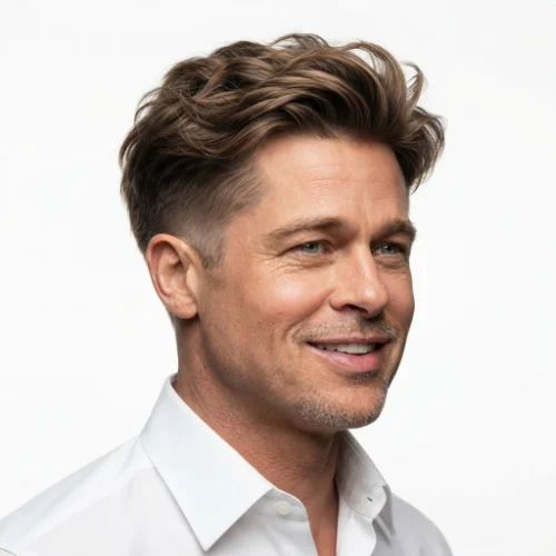 Man with medium-length fluffy hair and a low taper fade on a white background.