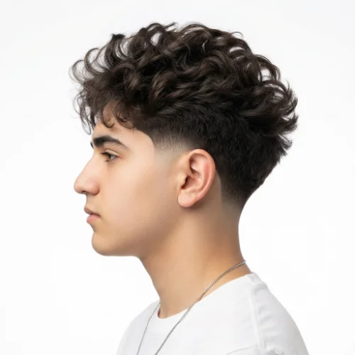 with textured hair styled into a low taper fade blowout with natural movement on a white background.
