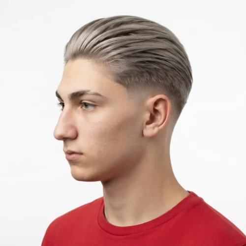 Man with slicked back blonde hair and a low taper fade on a clean white background.