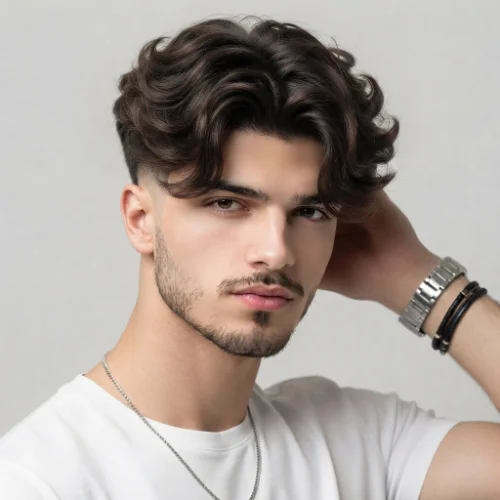 Man with textured curtain hair and a low taper fade featuring natural movement on a white background.